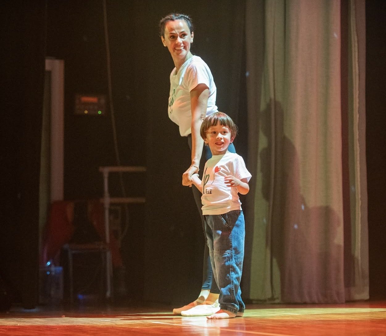 Insegnante accompagna un bambino sul palco durante lo spettacolo