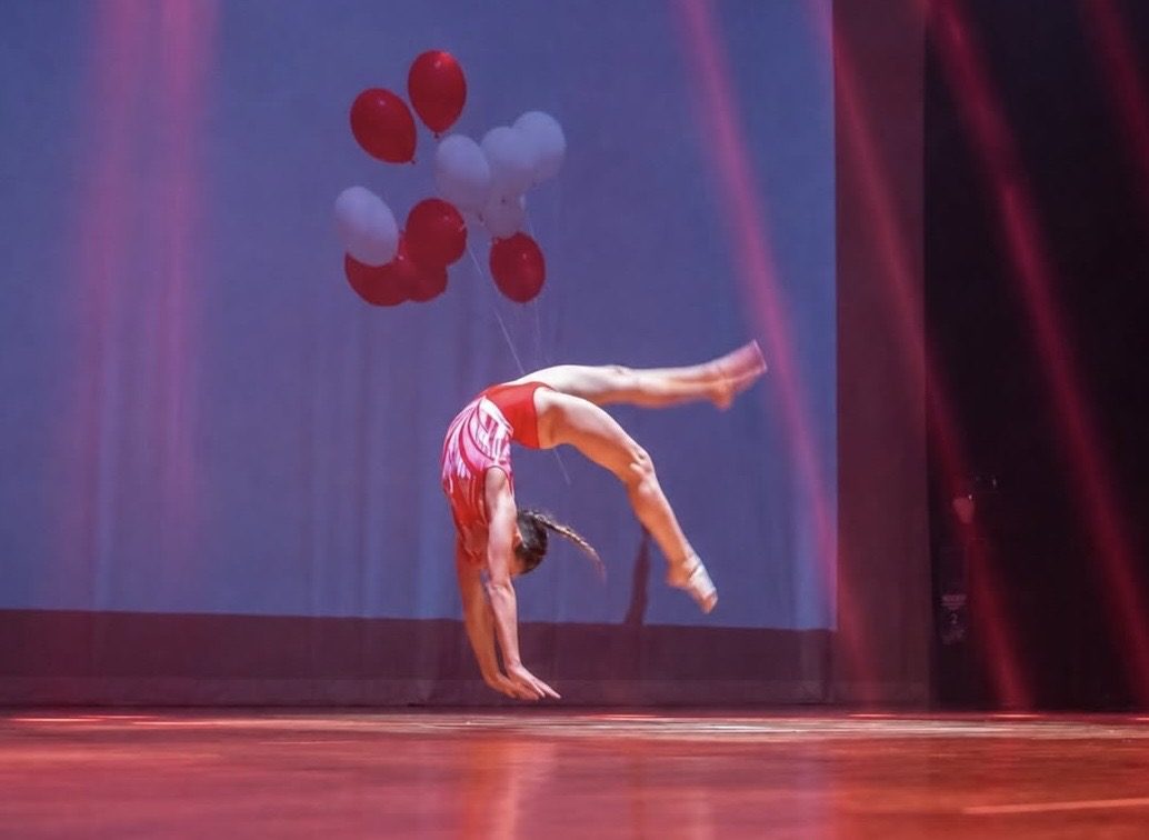Elemento di ginnastica artistica sul palco tra i palloncini durante il saggio