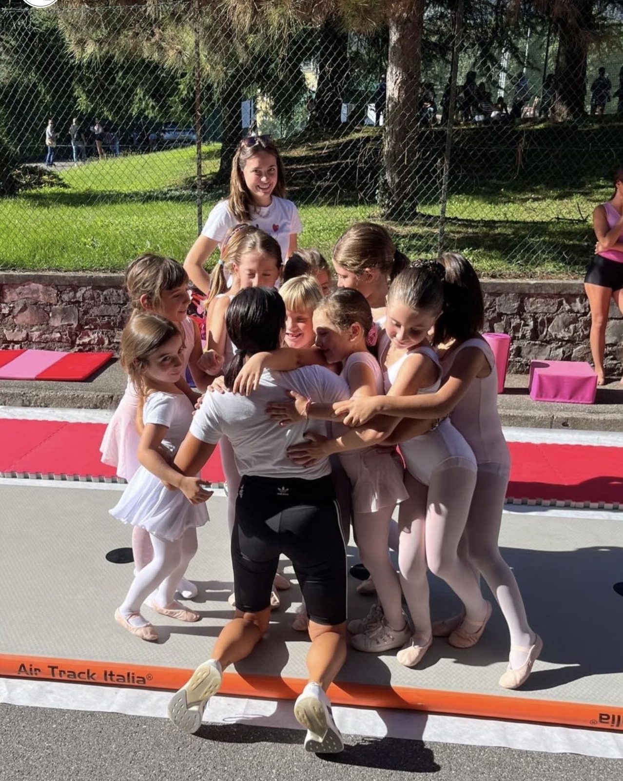 Bambine e bambini di Up A.s.d. in un abbraccio di gruppo durante un allenamento all'aperto